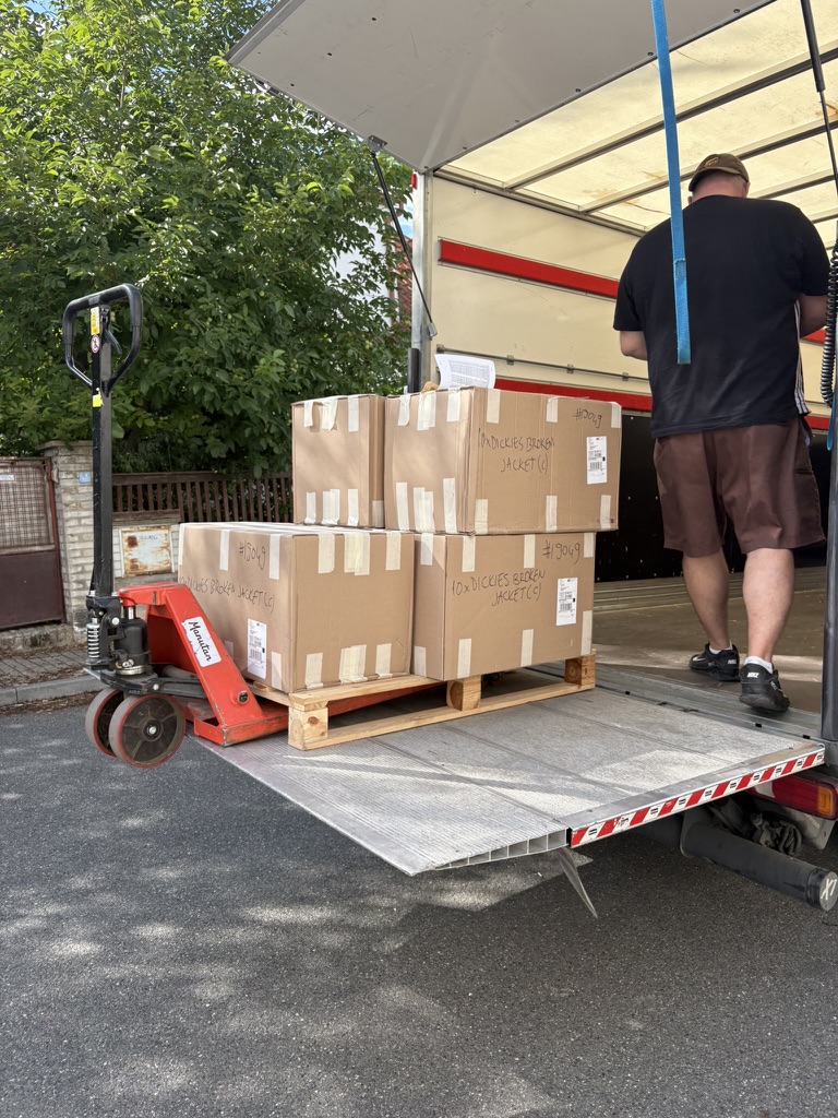 Pallet of boxed stock being unloaded from a delivery truck